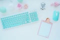 Computer mouse and keyboard in mint white, pink clipboard, paper clip, candle, alarm clock, pink paper flower on a white table. Fl Royalty Free Stock Photo