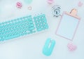 Computer mouse and keyboard in mint white, pink clipboard, paper clip, candle, alarm clock, pink paper flower on a white table. Fl Royalty Free Stock Photo