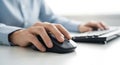 close up of hands using a computer mouse and keyboard on a white desk, showcasing technology and office work environment Royalty Free Stock Photo