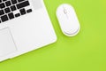 Computer mouse and laptop on a green background isolated, flat lay. Royalty Free Stock Photo