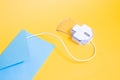 computer mouse made of transparent plastic and paper blue envelope on a yellow background