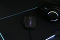 Computer mouse, mousepad and headset on black background, closeup Royalty Free Stock Photo