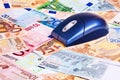 Computer mouse over Euro banknotes.