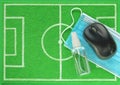 Computer mouse and sanitizer with blue medical mask placed on mini football field made of green felt, top view. Concept stay home. Royalty Free Stock Photo