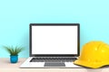 Safety helmet with laptop computer white blank screen on wood work table front view Royalty Free Stock Photo