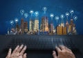 Computer networking and internet connection. Hand typing computer keyboard and buildings with social networking and application ic Royalty Free Stock Photo