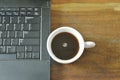 Computer notebook and black coffee cup on table Royalty Free Stock Photo