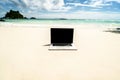 Computer notebook with empty black screen on the sandy tropical beach - digital nomad concept Royalty Free Stock Photo