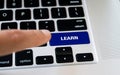 Computer notebook keyboard with Learn key, silver laptop with black keyboards, finger want to press the key Royalty Free Stock Photo