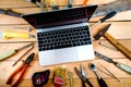 Computer and old tools on a wooden natural background. Royalty Free Stock Photo