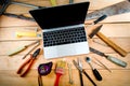 Computer and old tools on a wooden natural background. Royalty Free Stock Photo