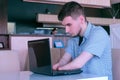 Disabled man freelancer with amputated two stump hands in cafe works on laptop. Royalty Free Stock Photo