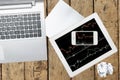 Computer, paper, smartphone and tablet with graph on wood table Royalty Free Stock Photo