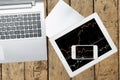 Computer, paper, smartphone and tablet with graph on wood table Royalty Free Stock Photo