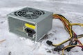 A computer power supply lies in a landfill in the snow Royalty Free Stock Photo