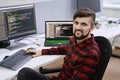 Computer programmer developer working in IT office, sitting at desk and coding, working on a project in software Royalty Free Stock Photo