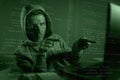Computer programmer man in hoodie hacking system entering code pointing to laptop hacking and decoding system data illegal access Royalty Free Stock Photo