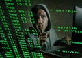 Computer programmer man in hoodie hacking system entering code typing on laptop hacking and decoding system data illegal access Royalty Free Stock Photo