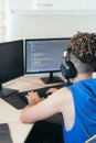 Computer programmer sitting at desk and typing on computer keyboard while creating code while working at home Royalty Free Stock Photo