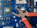 Computer repair concept. Old rusty passages on a blue laptop motherboard. The concept of unskilled work Royalty Free Stock Photo