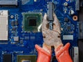 Computer repair concept. Old rusty passages on a blue laptop motherboard. The concept of unskilled work Royalty Free Stock Photo