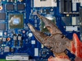 Computer repair concept. Old rusty passages on a blue laptop motherboard. The concept of unskilled work Royalty Free Stock Photo