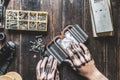 Computer repair master with dark dirty hands cleaning the electronic piece on the table f Royalty Free Stock Photo