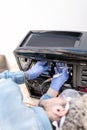 Computer repair service worker cleaning desktop computer with compressed air gun Royalty Free Stock Photo