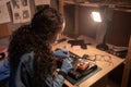 Computer retro repair shop. Female engineer performing laptop maintenance. Hardware developer fixing electronic