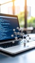 Computer screen displaying code next to a molecular model on a laptop keyboard Royalty Free Stock Photo