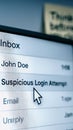 Computer screen displaying an email inbox with a cursor hovering over a suspicious login attempt message, illustrating a Royalty Free Stock Photo