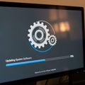 Computer screen displaying system update progress with spinning gears and loading bar Royalty Free Stock Photo