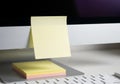 A computer screen displays a sticky note on its frame, with additional yellow and pink sticky notes Royalty Free Stock Photo