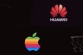 Computer screen with HUAWEI logo and smart phone with APPLE logo