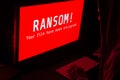 Computer screen with ransomware attacks alert in red and a man k