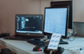 Computer screens running programming code in empty software developing agency office and computers parsing data