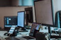 Computer screens running programming code in empty software developing agency office and computers parsing data
