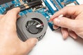 Computer service. Close up image of male technician engineer hand cleaning the dust from the laptop computer fan near the circuit Royalty Free Stock Photo