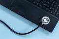 Computer servise and repair concept - kayboard with stethoscope Royalty Free Stock Photo