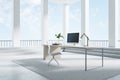 Computer standing on a desk in a bright room with white columns, stairs and big windows, black desktop, corner view. Work place Royalty Free Stock Photo