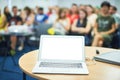 Computer on the table, blur image of conference room with people as background. Royalty Free Stock Photo