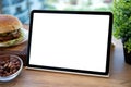 Computer tablet with isolated screen table background burger in cafe Royalty Free Stock Photo