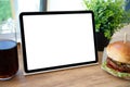 Computer tablet with isolated screen table background burger in cafe Royalty Free Stock Photo