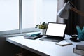 Tablet, potted plant, coffee cup and stationery on white table at bright living room. Royalty Free Stock Photo