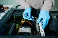 Computer technician in gloves safely repairing desktop hardware. Close-up view of hands fixing GPU and motherboard inside open PC Royalty Free Stock Photo