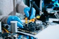 Computer technician in gloves safely repairing desktop hardware. Closeup view of hands fixing GPU and motherboard inside open PC Royalty Free Stock Photo