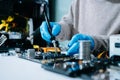 Computer technician in gloves safely repairing desktop hardware. Closeup view of hands fixing GPU and motherboard inside open PC Royalty Free Stock Photo