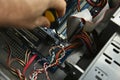 A computer technician repairing a desktop computer in a workshop.