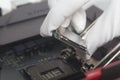 Computer technician wearing white gloves installing CPU into motherboard. Royalty Free Stock Photo