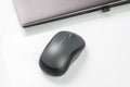 Computer wireless mouse next to a laptop on a white table close-up. electronic personal industry Royalty Free Stock Photo
